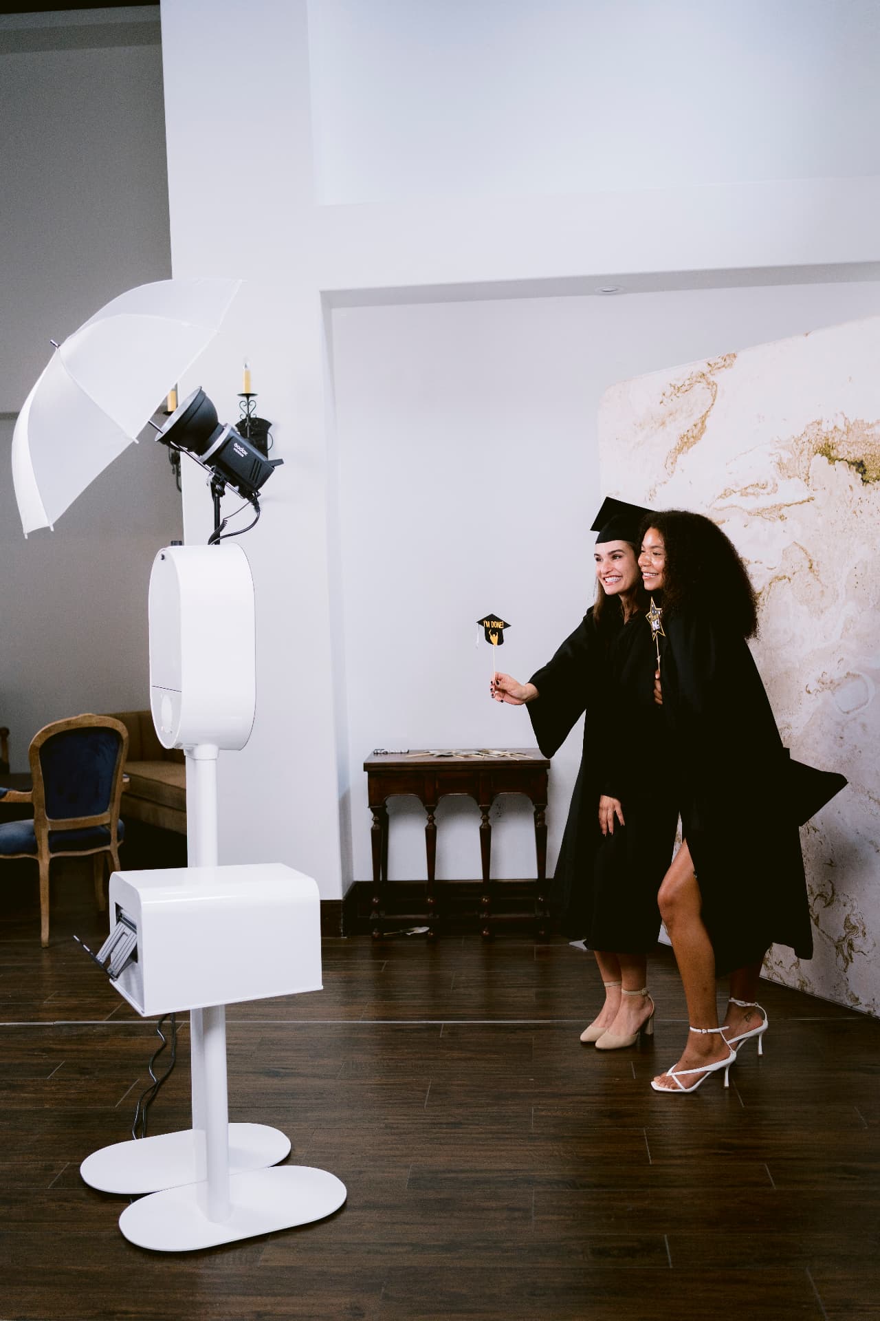 Graduates posing with props in front of the photo booth