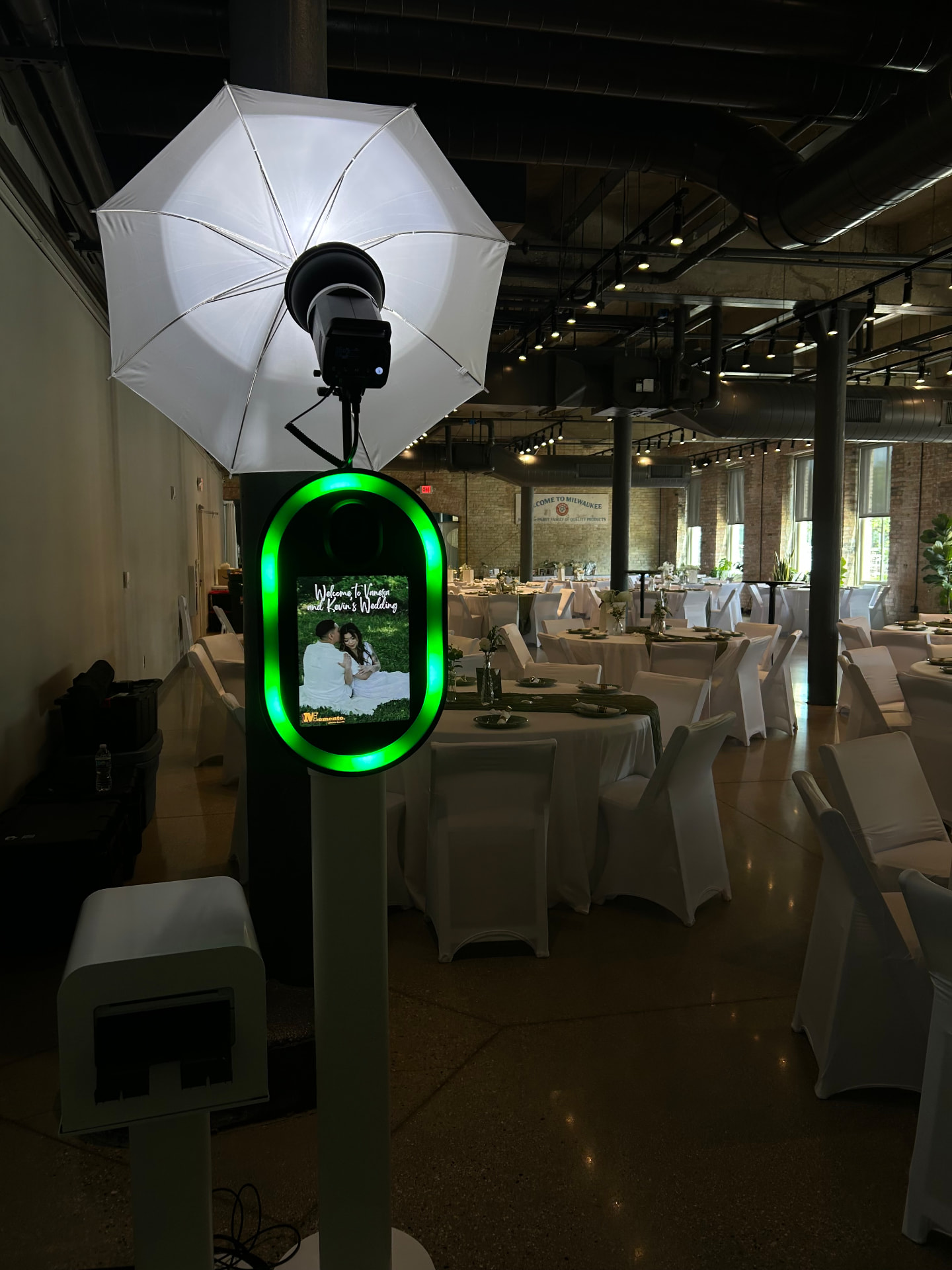 Memento photo booth with glowing green ring light and umbrella flash at an indoor wedding reception